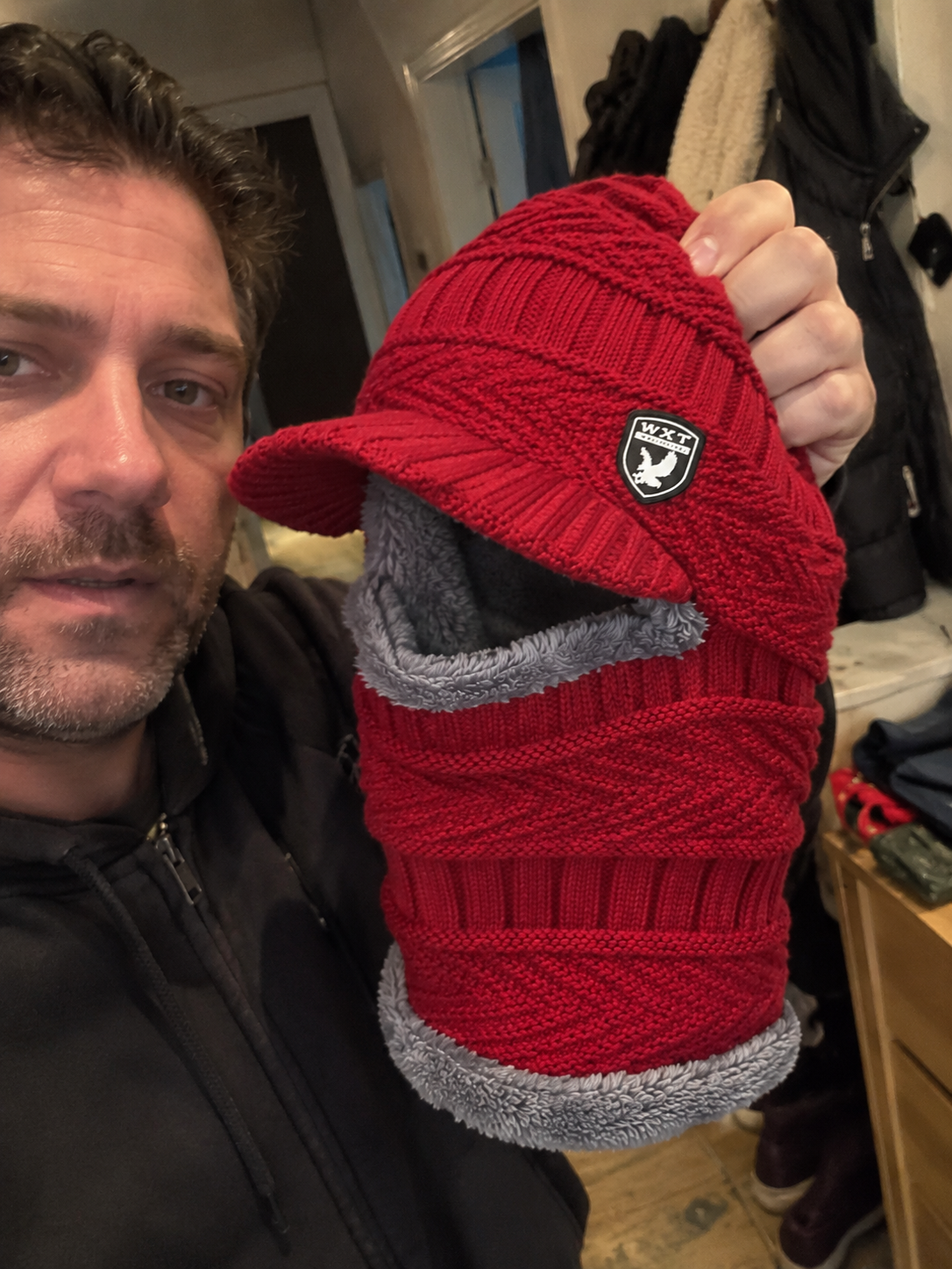 Man die een rode balaclava met zachte voering laat zien