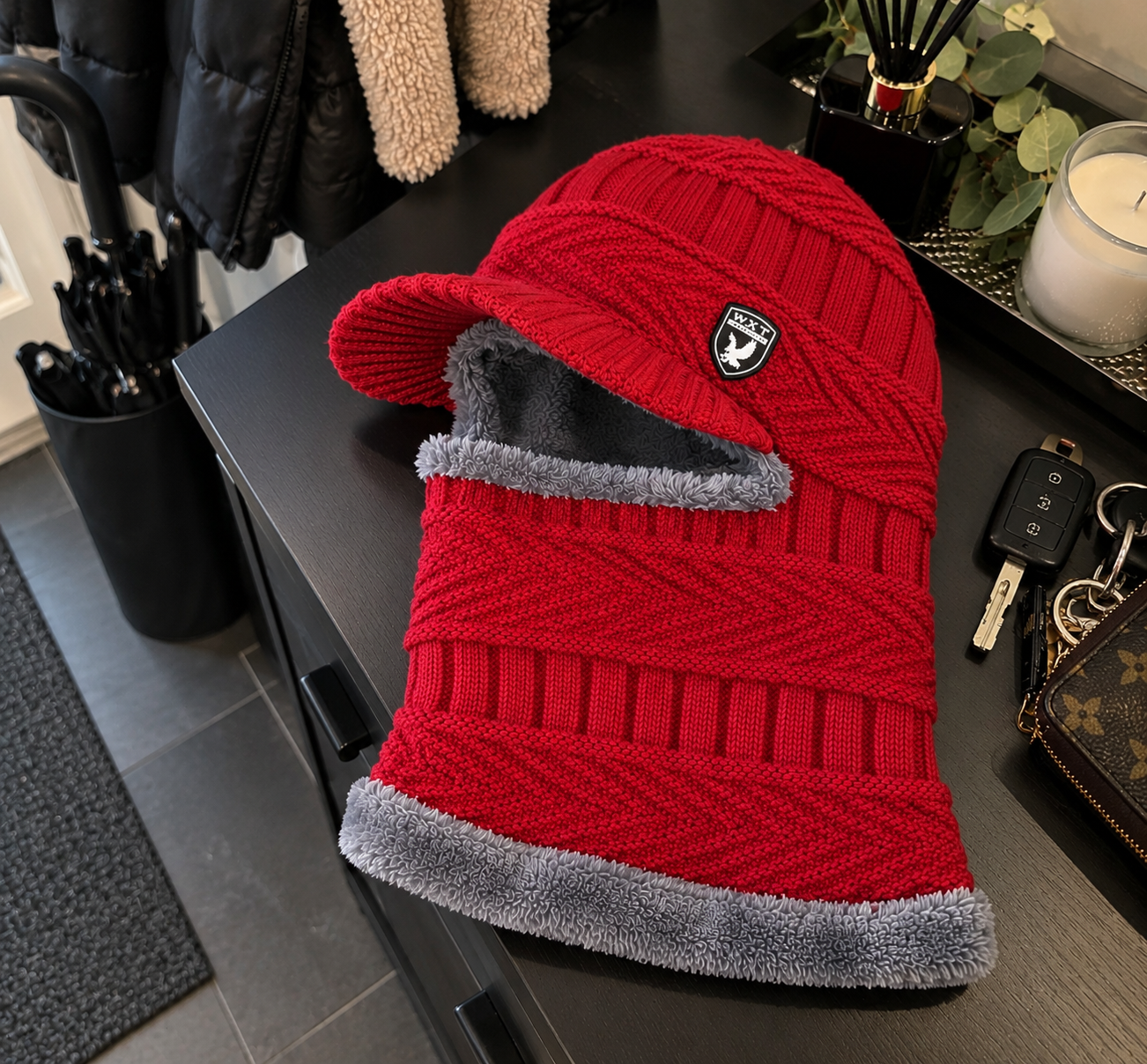 Rode balaclava met grijze voering op een kast